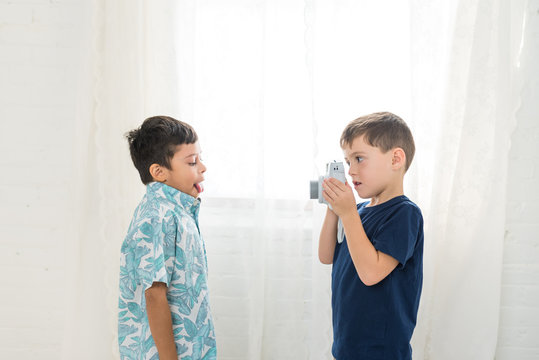 A Boy Takes A Photo Of His Friend