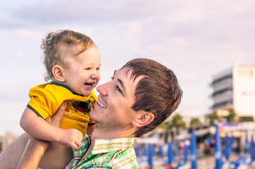 Happy father holding little happy son in his arms