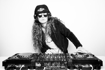 Portrait of curly hair young DJ playing music on light background
