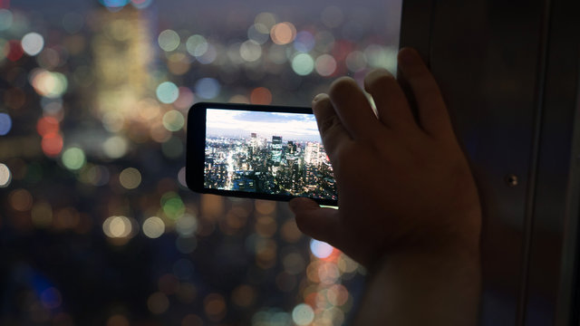 Unidentified Man Taking A Photo Of Tokyo Skyline With His Smart Phone From Tokyo Tower, Japan