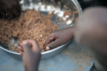 kids eating brown rice and fish in Africa - closeup