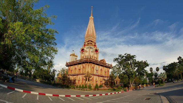 Phuket, Thailand - 28 November 2018 - Big high relics pagoda at Chalong temple or Wat Chaithararam, famous tourist attraction sightseeing,  with cloudy blue sky and green tree background