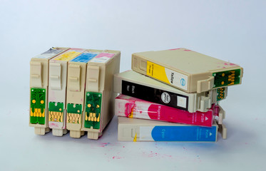 A jumbled stack of empty ink-jet printer cartridges on a white background.