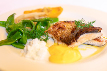 Delicious fish dish. White fish from the lake with a green paprika. Italian recipe. Selective focus.