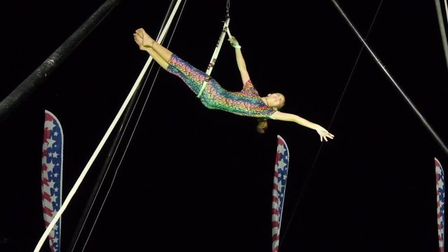 Young girl is an acrobat on a high ring