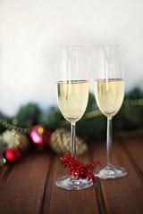 two New Year's glasses with champagne wine on a wooden table and a white background