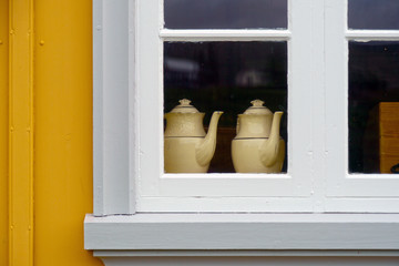 Two teapots in a window