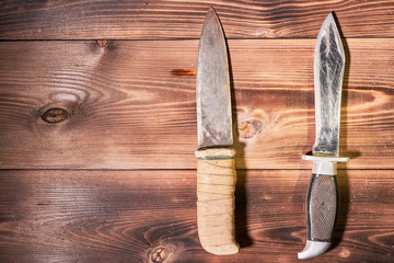 Hunting knives on wooden background. Top view