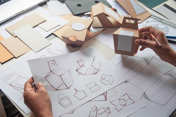 Designer sketching drawing design Brown craft cardboard paper product eco packaging mockup box...