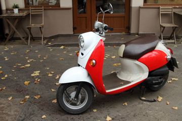 Red scooter parked at the entrance to the cafe.