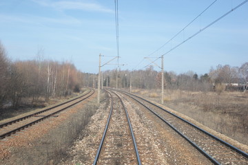 Fototapeta na wymiar railroad, trucks and dry grass seen from the end of a train - wide angle photo in Poland, Europe