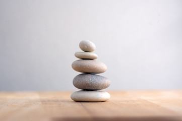 Stone cairn on striped grey white background, five stones tower, simple poise stones, simplicity harmony and balance, rock zen - obrazy, fototapety, plakaty