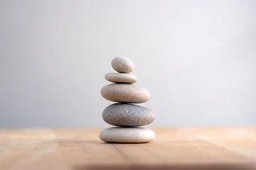 Selbstklebende Fototapete Zen Steinhaufen auf gestreiftem grauweißem Hintergrund, Turm mit fünf Steinen, einfache Poise-Steine, Einfachheit, Harmonie und Balance, Rock-Zen