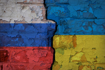 Brick wall with a crack painted on opposite sides in the Ukrainian and Russian flags