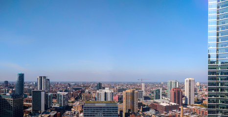 A wide aerial view of Chicago's Near West side, including Fulton Market district, from inside the top floor of a skyscraper. Panorama, urban cityscape.
