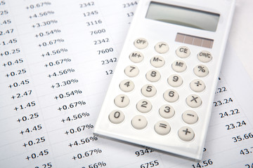 white calculator with numbers on a sheet