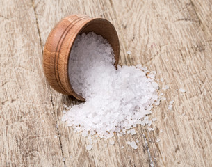 Fototapeta na wymiar Sea salt in a wooden bowl on wooden