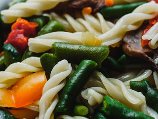 fusilli pasta with vegetables and mushrooms close-up