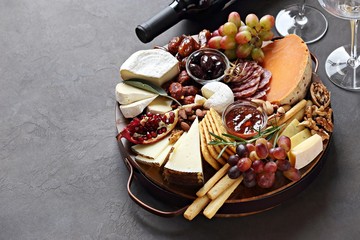 Appetizers platter with various of cheese, sausage, fruits and nuts. Cheese board. Overhead view,...