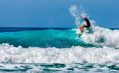Surferos practicando surfing en las olas.