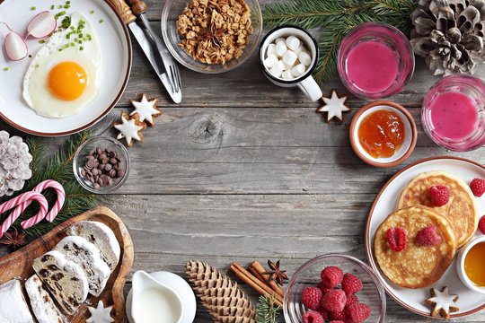 Christmas brunch or breakfast table. Festive brunch set, meal variety with fried egg, appetizers platter, pancakes, granola, smoothy and traditional sweets . Overhead view