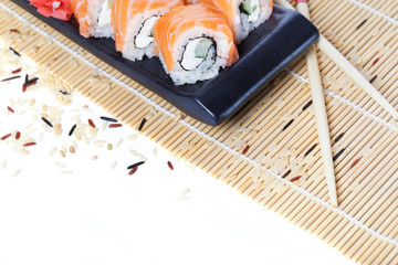 Fresh salmon sushi rolls on wooden background