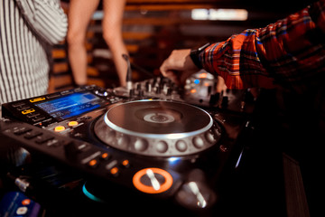 Dj mixes the track in the nightclub at party