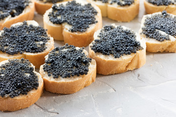 Expensive delicious black caviar white bread sandwich snack on wooden plate