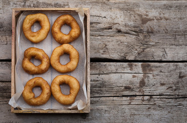 Homemade donuts with icing sugar powder on wooden background