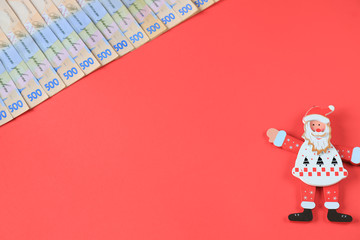 Ukrainian hryvna, banknotes 500 hryvnia, with toy Santa Claus  on rd background, concept of Christmas and New Year gifts and shopping . Ukraine