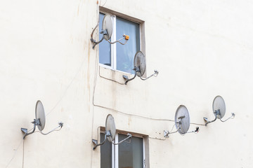 many satellite dishes on facade of house