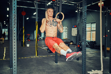 Obraz na płótnie Canvas Sports Man Training With Gymnastics Rings At Gym