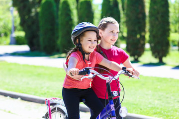 Obraz premium fun children ride a bike. Smiling kids summer vacation