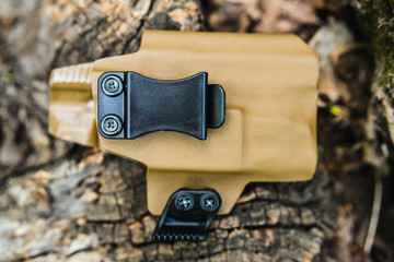 objective holster shooting on dry leaves in the forest
