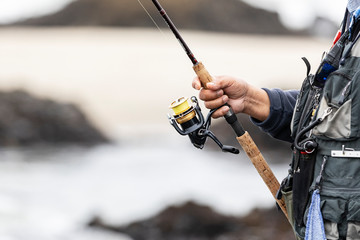 Closeup of mans hand on fishing rod and reel