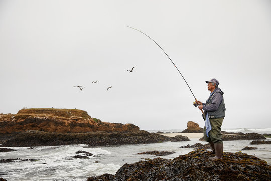 Portrait Of Retired Man Fishing At The Ocean