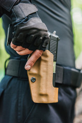 the guy puts the gun in the holster close-up