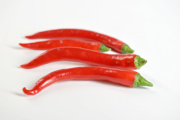 A few pods of red chili peppers. White background. Close-up.