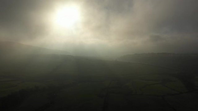 Surreal scene flying through morning mist in Yorkshire's Peak District