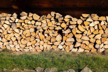 A heap of firewood by the wall of the house