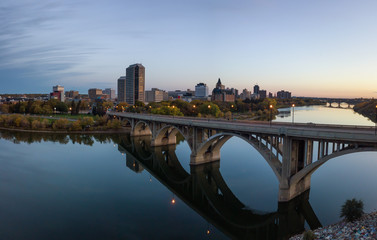 Aerial panoramic view of a bridge going over Saskatchewan River during a vibrant sunrise in the...