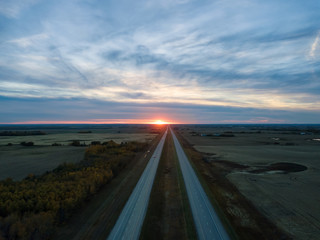 Aerial view of the Highway in the Prairies during a vibrant cloudy sunset. Taken East of Edmonton,...