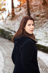 young woman standing outdoors in the cold and looking scared