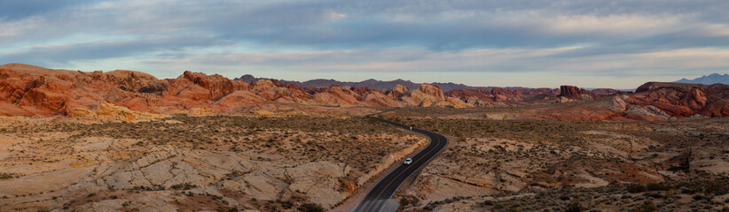 Aerial panoramic view on the scenic road in the desert during a cloudy sunrise. Taken in Valley of Fire State Park, Nevada, United States.