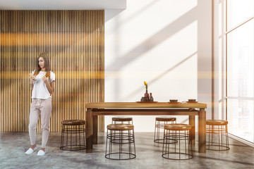 White and wooden dining room interior, woman