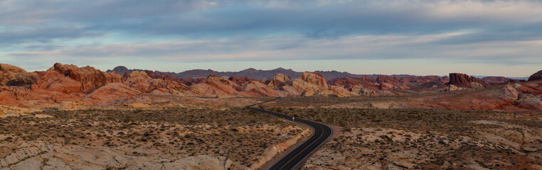 Aerial panoramic view on the scenic road in the desert during a cloudy sunrise. Taken in Valley of Fire State Park, Nevada, United States.
