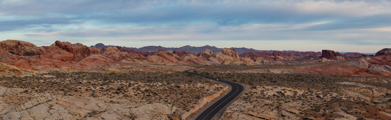 Aerial panoramic view on the scenic road in the desert during a cloudy sunrise. Taken in Valley of Fire State Park, Nevada, United States.