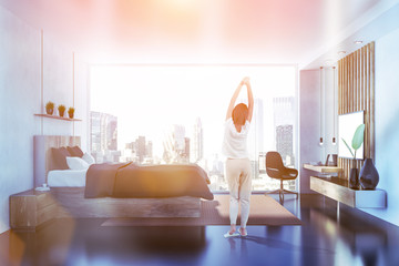 Gray bedroom with tv side view, woman