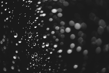 Dirty window glass with drops of rain. Atmospheric monochrome dark background with raindrops in...