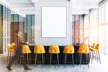 Gray bar interior, yellow chairs and poster, man